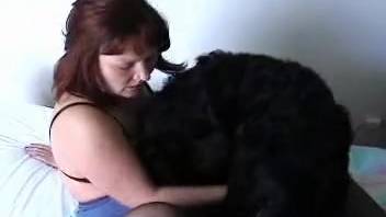 Attractive ginger babe and black dog enjoy a pleasant homemade bestial encounter